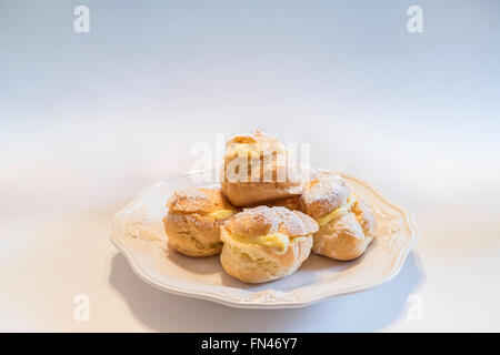 Hausgemachte Windbeutel auf einem weißen Teller. Stockfoto