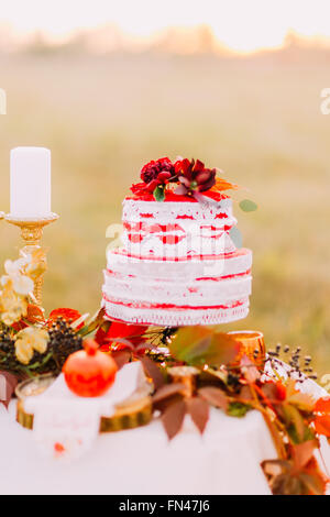 Hochzeitstorte auf dem Tisch dekoriert mit abgefallenen Blättern Stockfoto