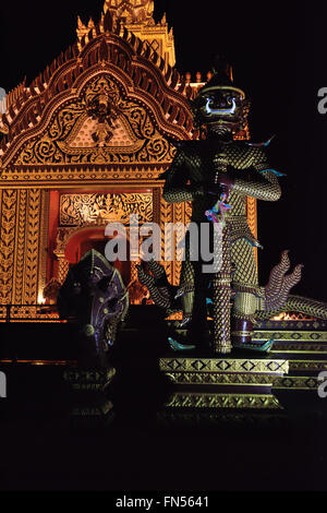 Einen riesigen Tempelwächter vor einem kleinen Saal neben dem Schrein Halle des Wat Khao Kalok in Pranburi, Thailand beleuchtet ein Stockfoto