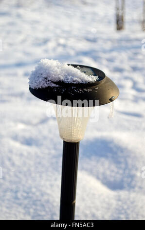 Schwarzer Garten Solarleuchte auf Schnee im winter Stockfoto