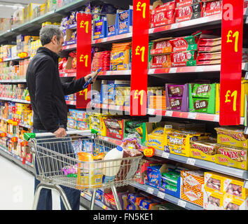 Reifen männlichen Shopper Schokoladenkekse in Asda Speicher zu kaufen. UK Stockfoto