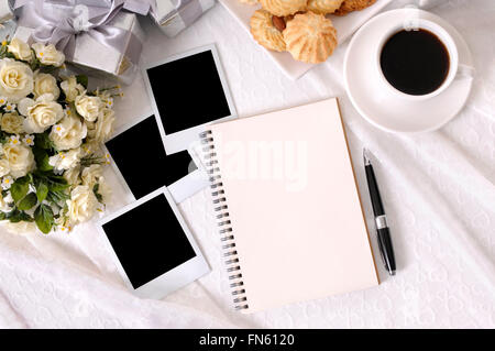 Hochzeitsalbum oder ein Notebook mit leeren Fotoabzüge auf Braut Spitze mit mehreren silberne Hochzeitsgeschenke und Stoff Bouquet gelegt Stockfoto