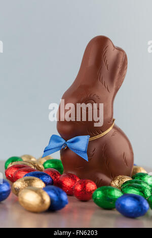 Schokoladen-Ostereier verpackt in bunten Folien und Hase. Geringe Schärfentiefe. Stockfoto