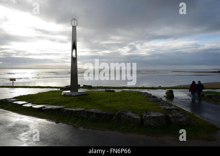 Wanderer auf Outdoor-Skulptur mit dramatischer Himmel und Meer Millenium Coastal Path in Burry Port, Wales. Stockfoto