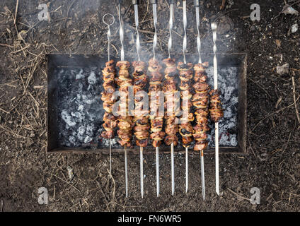 Appetitliches Frischfleisch Schaschlik auf einem Holzkohle Grill zubereitet. Draufsicht des Kochens Schaschlik Stockfoto