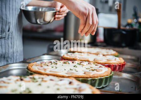 Hand des Hinzufügen von Kräutern und Kochen Kuchen Küche kochen Stockfoto