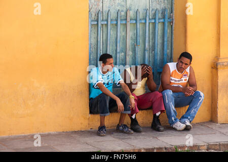 Alltag in Kuba - junge Männer saßen auf Schritte auf Trinidad, Kuba, Westindische Inseln, Karibik, Mittelamerika im März Stockfoto