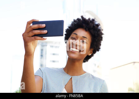 Glücklich junge afroamerikanische Frau, die eine Selfie mit ihrem Handy Stockfoto