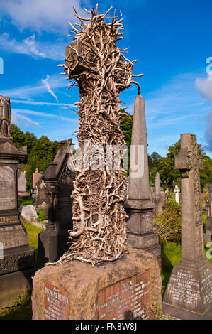 Ein Kreuz auf einem Grabstein in Efeu in Edgerton Friedhof, Huddersfield, West Yorkshire England abgedeckt Stockfoto