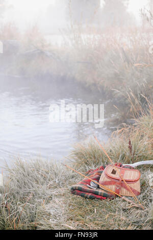 Eine Fischerei Gatter und Decke am Ufer des Flusses mit zwei leichte Ruten. Stockfoto