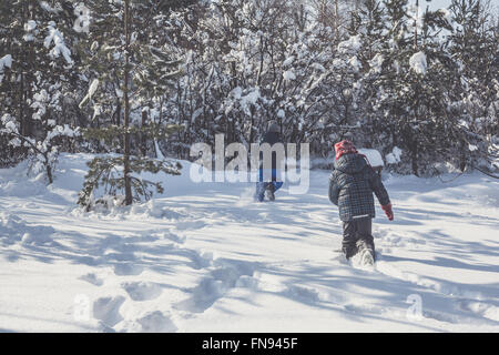 Jungen und Mädchen spielen im Schnee Stockfoto