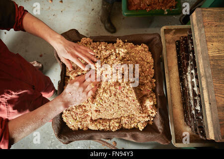 Draufsicht auf den Apfelwein-Maker drücken das Fruchtfleisch in den Rahmen in die Mostpresse. Stockfoto