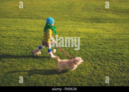 Mädchen, die golden Retriever Welpen Hund spazieren Stockfoto