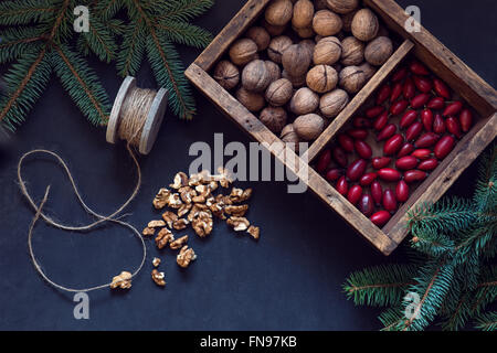 Draufsicht der Walnüsse und Hagebutten in einer Holzkiste Stockfoto