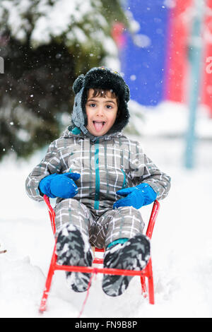 Bildnis eines Knaben mit seiner Zunge Schneeflocken fangen Stockfoto