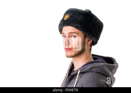 Kopfschuss von schönen blonden Jüngling, russische Pelzmütze tragen. Guy hat blaue Augen, isoliert auf weiss Stockfoto