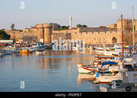 Rhodos Stadt, Rhodos, südliche Ägäis, Griechenland. Kolona-Hafen Blick auf die Stadtmauern, Sonnenaufgang, prominente Marine Tor. Stockfoto