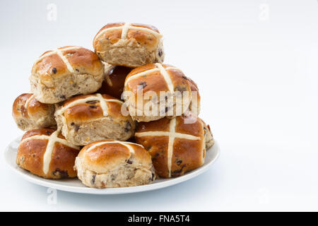 Eine Platte voll von frisch gebackenen Ostern, Hot Cross Buns auf einem weißen Hintergrund. Stockfoto