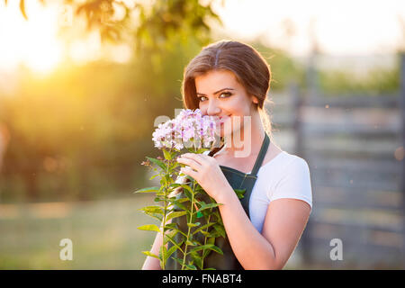 Junge Gärtner in ihrem Garten, Blumen, sonnige Natur riechen Stockfoto