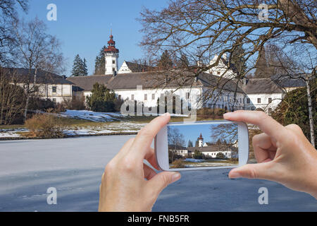 In der rechten unteren des Fotos sind Hände halten Smartphone und unter Bild von Velké Losiny Burg in Tschechien Stockfoto