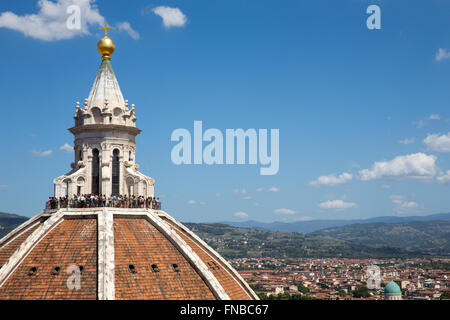 Touristen stehen oben auf Brunelleschis Kuppel an der Kathedrale von Florenz in Italien mit Blick auf die Stadt und die Landschaft der Toskana. Stockfoto