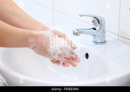 Waschen der Hände mit Seife unter fließendem Wasser. Hygiene und Reinigung der Hände. Stockfoto