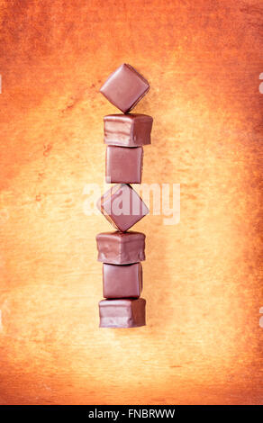 Reihe von Schokoladentrüffel übereinander auf einem Pergament-Papier-Hintergrund. Stockfoto