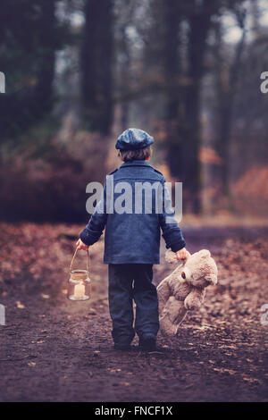 Niedliche kleine Kind, Vorschule junge, hält Laterne und Teddybär, in einem dunklen Wald wandern Stockfoto