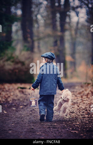 Niedliche kleine Kind, Vorschule junge, hält Laterne und Teddybär, in einem dunklen Wald wandern Stockfoto