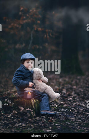 Niedliche kleine Kind, Vorschule junge, hält Laterne und Teddybär, in einem dunklen Wald wandern Stockfoto