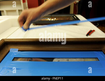 Bremen, Deutschland. 14. März 2016. Spezialisten für Kunst Elektromobilen Verpackung im Gemälde von Paula Modersohn-Becker Museum Boettcherstrasse in Bremen, Deutschland, 14. März 2016. Spezialklebeband wird verwendet, um das Glas vor dem brechen zu verhindern. 12 Modersohn Werke sind verpackt in weißen klimatischen Boxen für den Transport nach Paris, Frankreich. Das Museum Boettcherstrasse verleiht die wertvollen Gemälden eine Retrospektive von Paula Modersohn-Becker (7. April, 21. August 2016) in der französischen Hauptstadt. Foto: INGO WAGNER/Dpa/Alamy Live News Stockfoto