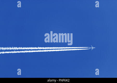 Flugzeugen Blätter Spur am strahlend blauen Himmel. Die Ablaufverfolgung Kondensstreifen, Kondensstreifen oder Vapor Trails, genannt gepresst durch Flugzeuge Stockfoto