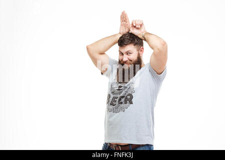 Verspielte lustige bärtiger Mann macht Bunny Ohren mit den Händen auf weißem Hintergrund Stockfoto