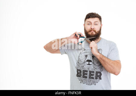 Traurig wütend bärtiger Mann seinen Bart mit einer Schere schneiden, auf weißem Hintergrund Stockfoto