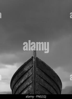 Vertikale Blick nach vorne auf einem alten Fischerboot Holz mit verrosteten Nägel mit dramatischen graue Gewitterwolken im Hintergrund Stockfoto