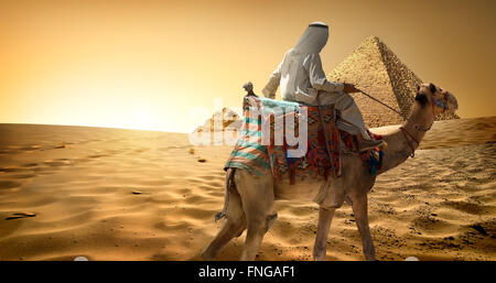 Beduinen auf Kamel im Sand der Wüste in der Nähe von Pyramiden Stockfoto