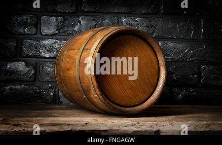 Ziegelmauer und Holzfass im Keller Stockfoto
