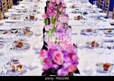 Festlichen Tisch mit Blumensträuße und Vorspeisen in einem restaurant Stockfoto