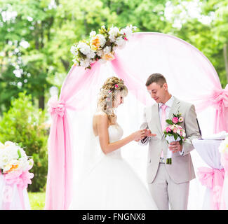 Braut Bräutigam seine Finger während der Trauung einen Ring aufsetzen Stockfoto
