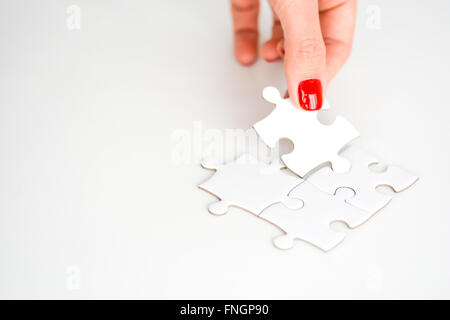 Frau Hand passend das richtige Stück puzzle vorgeschlagen Business-Networking-Konzept Stockfoto