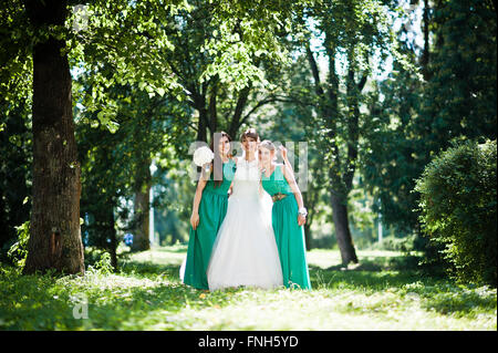 Wunderschöne Braut mit Brautjungfern auf Sunshine Park gestellt Stockfoto