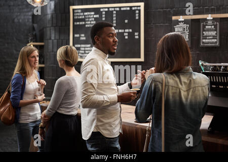Gemischte Rassen Freunde reden an der Theke der Cafeteria Stockfoto
