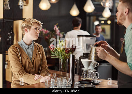 Frau, die in einem modernen Café Kaffee Verkostung Stockfoto