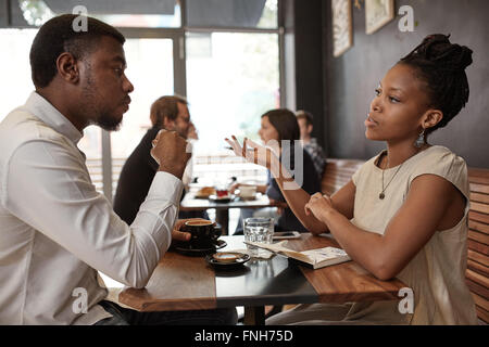 Afrikanische Frau und Mann diskutieren Geschäftsideen im belebten café Stockfoto