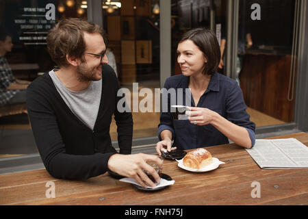 Lächelnde junge stilvolle paar an einem Kaffee Datum im freien Stockfoto