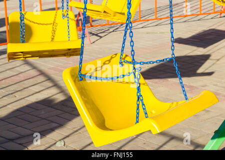 Attraktion gelbe schwingen an einer Kette Stockfoto