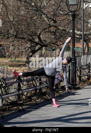 Ein sieben Monate schwangere Frau dehnen tut Übungen in einem Park in Manhattan, New York City Stockfoto