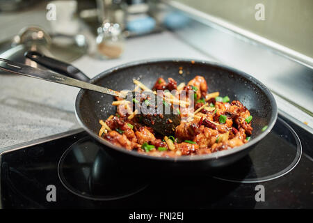 Nahaufnahme von einem thai Rezept mit karamellisierten Hähnchenflügel in einem wok Stockfoto