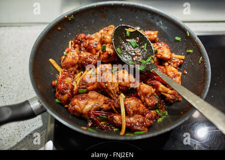 Nahaufnahme von einem thai Rezept mit karamellisierten Hähnchenflügel in einem wok Stockfoto