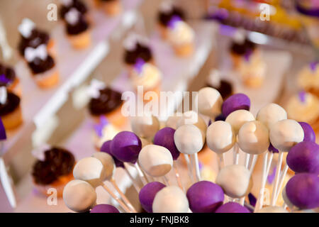 Weiß und lila Lutscher mit vielen Kuchen im Hintergrund Stockfoto